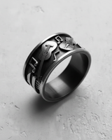 Angled view of the sterling silver musical instrument ring, highlighting the 3D relief of the guitar and piano keys.