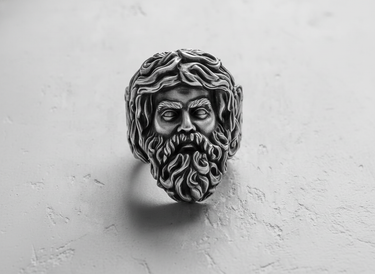 Oxidized Silver Zeus Ring with intricate details in the beard and hair, shown from a direct front view on a textured white background.