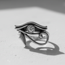Sterling silver Eye of Horus ring, unplated version, casting a strong shadow to highlight the polished finish and details.