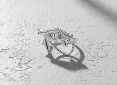 Polished 925 sterling silver Eye of Horus ring with a central bezel-set gemstone, shown on a textured white surface.