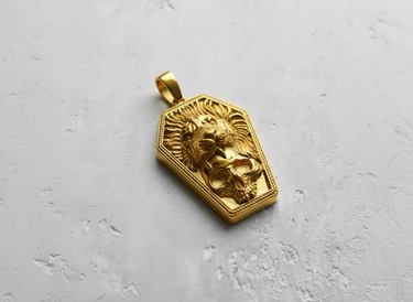 Gold vermeil coffin shaped pendant featuring a roaring lion and skull design on textured background