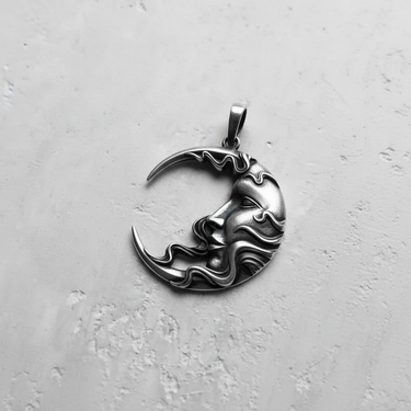 Angled view of the handcrafted sterling silver moon face pendant, highlighting the three-dimensional facial features and bail.
