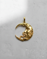 Gold vermeil crescent moon face pendant with flowing hair design on white background