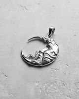 Close-up of the art nouveau style silver moon face pendant, showing the flowing hair details and polished highlights.