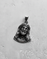 Angled view of handcrafted silver Christ pendant highlighting the dimensional religious craftsmanship