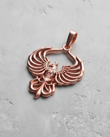 Rose gold plated silver phoenix pendant with detailed spread wings design on grey background