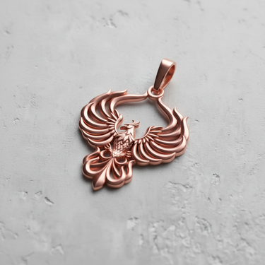 Rose gold plated silver phoenix pendant with detailed spread wings design on grey background