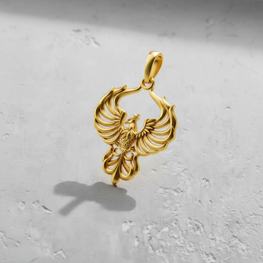 Gold vermeil phoenix pendant with symmetrical spread wings casting a shadow on grey surface