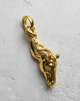 14K gold vermeil silver horse pendant with a flowing mane design, shown from a top-down angle on a light textured background.