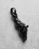 Black rhodium plated silver horse pendant with a stylized, flowing mane detail, shown from a side angle on a textured surface.