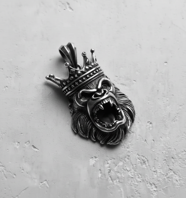 Close-up of the sterling silver king gorilla pendant's fierce expression and crowned head against a plain, light background.