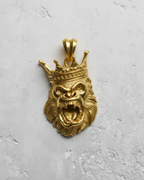 14K gold vermeil king gorilla pendant with a detailed crown and roaring expression, photographed on a light textured surface.