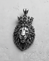Close-up of the handcrafted silver lion pendant, focusing on the oxidized details within the crown and the lion's piercing eyes.