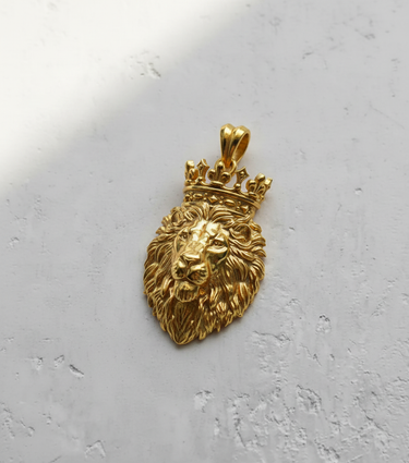 14K gold vermeil crowned lion pendant showing detailed mane and regal crown, angled on a light grey textured surface.