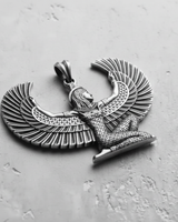 Silver Egyptian Isis Pendant showing the detailed feather texture on the outstretched wings and headdress, angled on a grey surface.