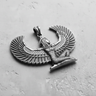 Angled view of handcrafted Egyptian winged goddess pendant showing intricate feather details and silver bale