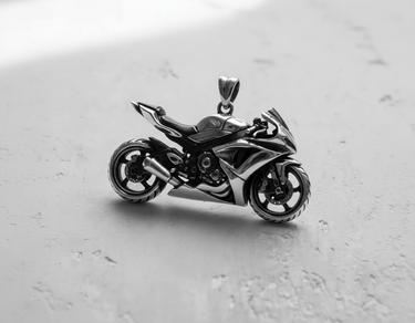 Three-quarter view of the silver motorcycle pendant, displaying its 3D depth, spoked wheels, and integrated bail for a necklace.