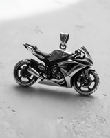 Angled side view of the 925 sterling silver motorcycle pendant, highlighting the spoked wheels, engine, and exhaust details.