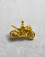 14K gold vermeil motorcycle pendant with detailed sport bike design shown top-down on a textured white surface.