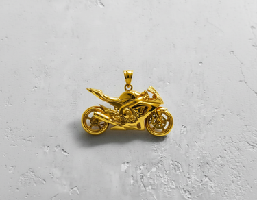 14K gold vermeil motorcycle pendant with detailed sport bike design shown top-down on a textured white surface.