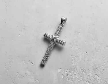 Polished 925 silver rustic cross pendant with a detailed wood grain texture and rope-wrapped center on a light background.