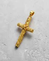 Gold vermeil rustic cross pendant featuring a detailed wood-grain texture and rope-wrapped center, angled on a white textured surface.