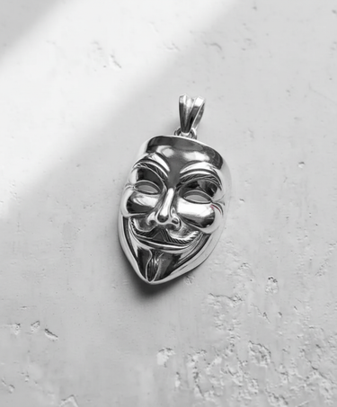 Close-up of the handcrafted Silver Guy Fawkes pendant, detailing the stylized smile and mustache on polished 925 silver.