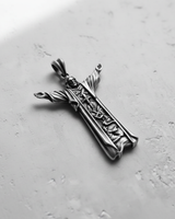 Angled top-down view of the handcrafted silver Jesus Christ pendant, highlighting the oxidized finish and outstretched arms.