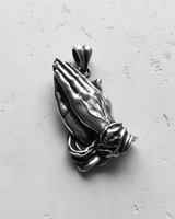 Top-down view of a 925 sterling silver praying hands pendant with an oxidized finish highlighting the intricate details.