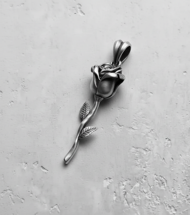 Top-down view of the handcrafted silver rose pendant, highlighting the intricate petals and bail on a light gray background.