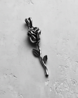 Angled shot of the handcrafted silver rose pendant, highlighting the oxidized finish and intricate details on the petals.