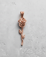 Rose gold plated silver rose pendant with detailed petals and long stem on textured background