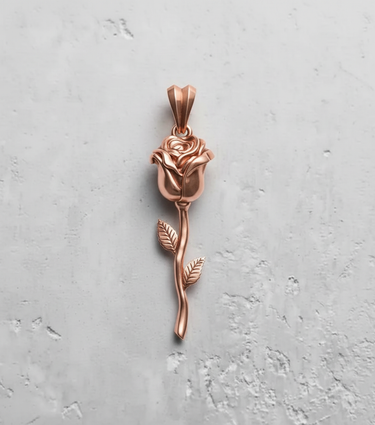 Rose gold plated silver rose pendant with detailed petals and long stem on textured background