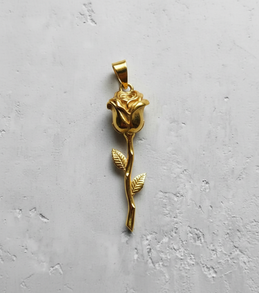 14K gold vermeil silver rose pendant with a long stem and two leaves, shown against a light textured background.