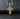 Angled view of gold vermeil religious pendant with Jesus face design on black textured surface