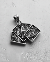 Oxidized 925 sterling silver playing card pendant with detailed carvings of the four kings on a textured concrete background.