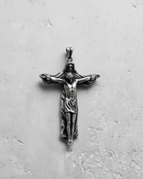 Oxidized 925 silver Jesus crucifix pendant featuring God the Father embracing Jesus on the cross, on a textured surface.