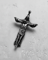 Studio shot of Jesus crucifix pendant available in gold vermeil and silver finishes on textured background