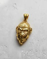 14K gold vermeil monkey pendant with a star bandana, showing detailed fur texture and intense eyes on a textured white surface.