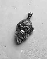 Oxidized silver monkey pendant with a star bandana, angled to show the detailed fur texture and furrowed brow.