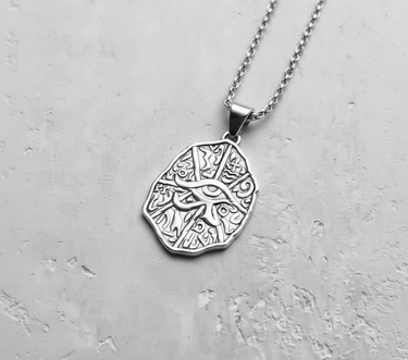 925 sterling silver Eye of Horus pendant with hieroglyphic details hanging on chain against white background