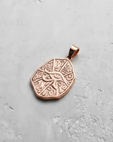 Rose gold plated Eye of Horus pendant with hieroglyphic texture on grey background