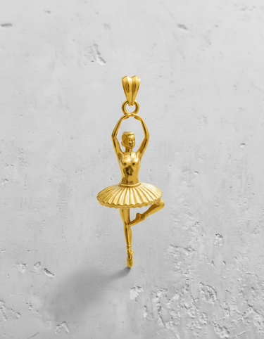 Gold-plated version of the ballerina dancer pendant, showcasing the warm tone and elegant design on a textured background.