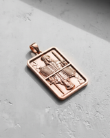 Rose gold vermeil silver Jack pendant in a playing card shape, with sunlight casting a shadow on a grey background.