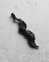 Black rhodium plated silver angel wing pendant with a stylized female figure, shown at an angle on a white textured surface.