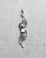 Polished silver angel wing pendant with a detailed female figure and flowing feathers, shown on a light gray textured background.