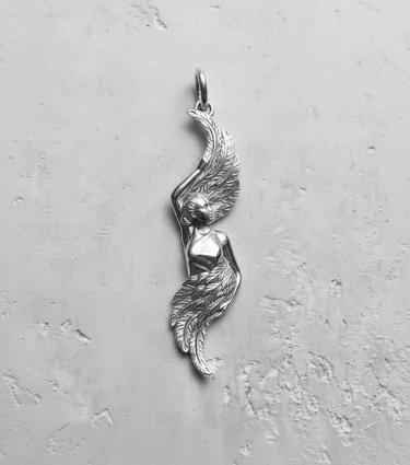 Polished silver angel wing pendant with a detailed female figure and flowing feathers, shown on a light gray textured background.