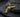 Gold vermeil over 925 sterling silver revolver pendant displayed on dark slate stone background
