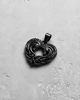 Black rhodium plated Silver Celtic Horse Pendant showing two horses forming a heart with knotwork, on a textured white surface.