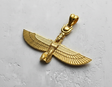 Gold vermeil Winged Goddess Pendant with detailed feathers and a sun disk headdress on a light gray textured surface.